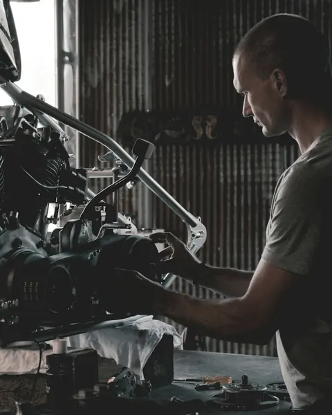 A mechanic working on an engine in a garage
